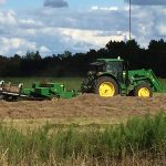 Green and yellow trailer in brown field